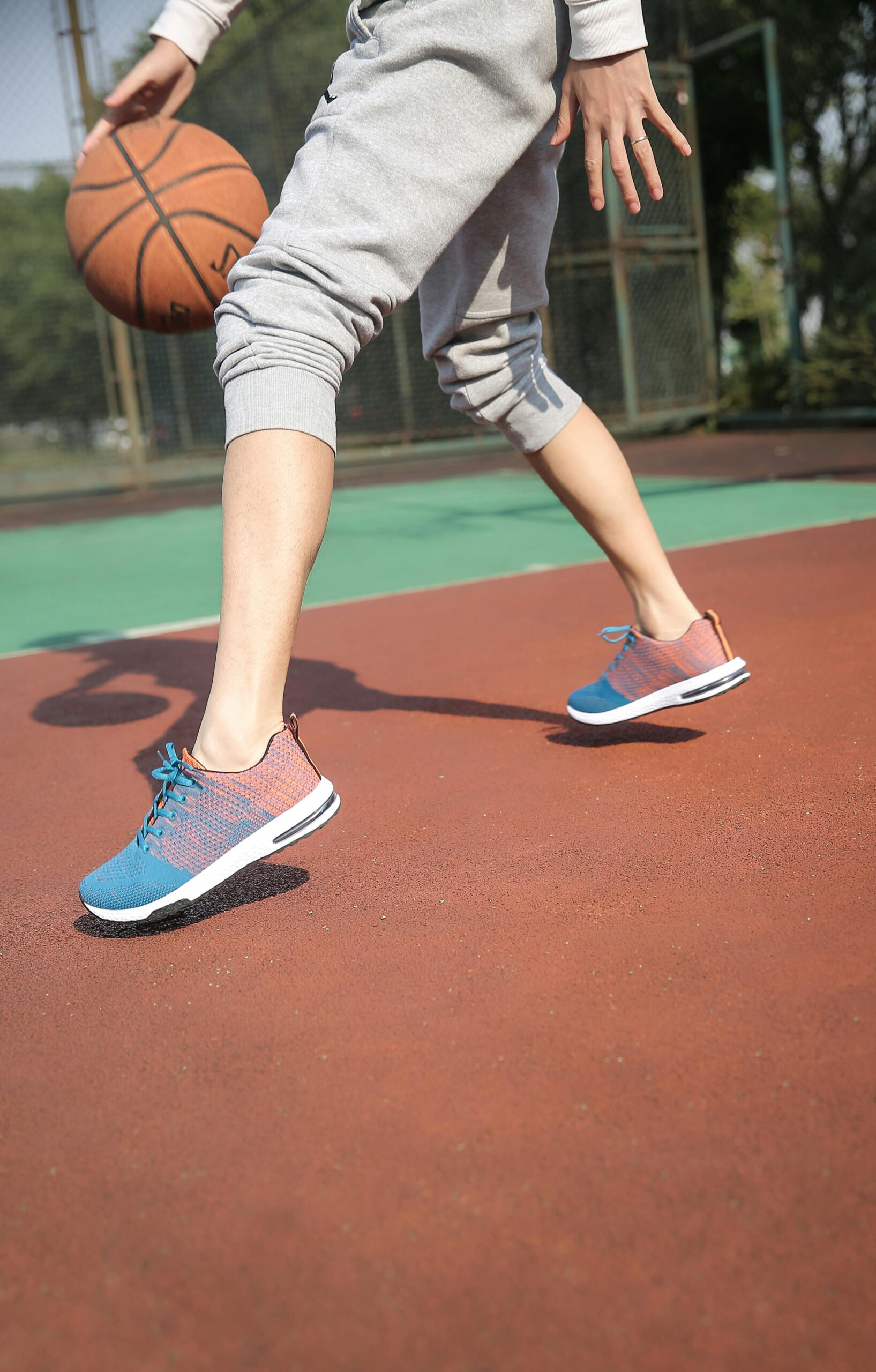 Person playing basketball wearing sports shoes.